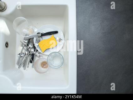 Évier de cuisine en céramique blanc plein de vaisselle sale non lavée Banque D'Images