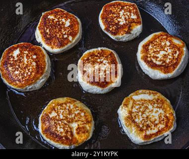 Les crêpes au fromage cottage sont frites dans une poêle avant d'être retirées Banque D'Images