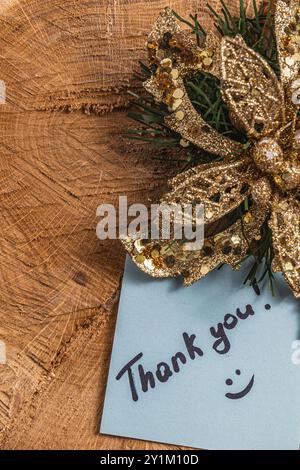 Le mot merci pour la lumière d'une feuille bleue sur un morceau de bois Banque D'Images