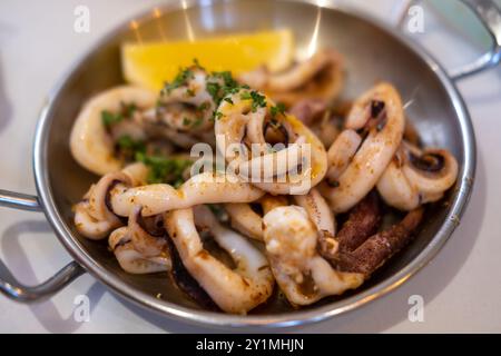 Calmar grillé aux légumes et au citron servi sur l'assiette Banque D'Images