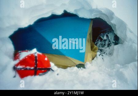 La tente de bivouac sur une petite corniche sur une montée hivernale dans le mur des Troll vertical de 3000 pieds dans la vallée de Romsdalen, Rauma kommune, Møre og Romsdal, Norvège. Février 1992. Banque D'Images