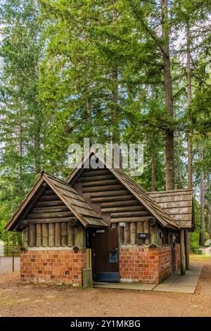 Toilettes rustiques en briques et en rondins construites par le Civilian conservation corps dans les années 1930 dans le parc d'État de Twanoh, État de Washington, États-Unis Banque D'Images