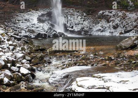 Les rochers à la base de Hardraw Force, la plus haute cascade d'Angleterre, sont recouverts de glace par une journée d'hiver enneigée en décembre Banque D'Images