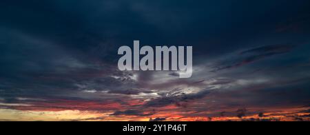 Les nuages du coucher du soleil se rassemblent. Ciel panoramique de lever ou de coucher de soleil avec des nuages. Coucher de soleil ciel sur crépuscule dans la soirée avec coucher de soleil. Nuage nature ciel Banque D'Images