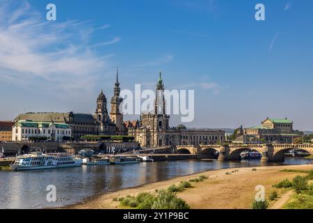 Dresdner Stadtbild Blick auf die Dresdner Altstadt mit der Katholischen Hofkirche auch bekannt als Kathedrale : Trinitatis im Zentrum. IM Vordergrund fließt die Elbe, auf der mehrere Schiffe zu sehen sind. Die historische Architektur und die Brühlsche terrasse prägen das Bild. Die Augustusbrücke verbindet die beiden Elbufer. Der Himmel ist klar und sonnig. Dresde Innere Neustadt Sachsen Deutschland *** paysage urbain de Dresde vue de la vieille ville de Dresden avec l'église de la cour catholique également connue sous le nom de cathédrale St Trinitatis au centre L'Elbe coule au premier plan, sur lequel plusieurs navires peuvent être Banque D'Images