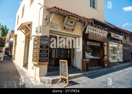 Rhodes Town, Grèce – 19 juillet 2024. Magasins dans la rue Sokratous à Rhodes Town, Grèce. La vue comprend la boulangerie Fournariko et la bijouterie Kasiotis Banque D'Images