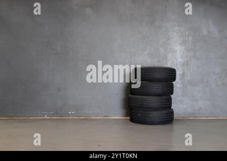 Pneus de voiture usagés empilés dans un garage Banque D'Images