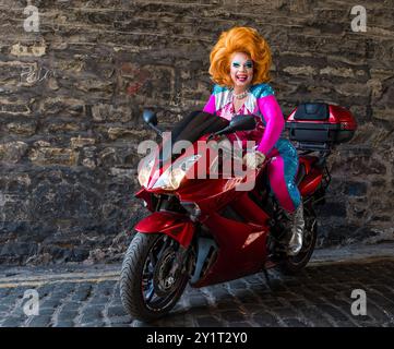 L'artiste Ginger Johnson sur une moto au Edinburgh Festival Fringe, Écosse, Royaume-Uni Banque D'Images