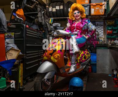 L'artiste Ginger Johnson sur une moto dans un atelier de réparation de motos à Edinburgh Festival Fringe, en Écosse, au Royaume-Uni Banque D'Images