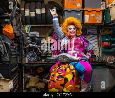 L'artiste Ginger Johnson sur une moto dans un atelier de réparation de motos à Edinburgh Festival Fringe, en Écosse, au Royaume-Uni Banque D'Images