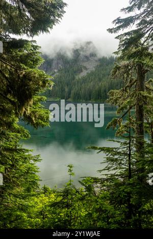 Des nuages s'attardent sur les montagnes entourant le lac Mowich dans le parc national du Mont Rainier Banque D'Images