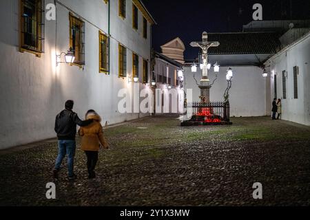 Un couple se promène sur la Plaza historique de Capuchinos à Cordoue, en Espagne, près du Cristo de los Faroles illuminé, capturant une nuit atmosphérique Banque D'Images