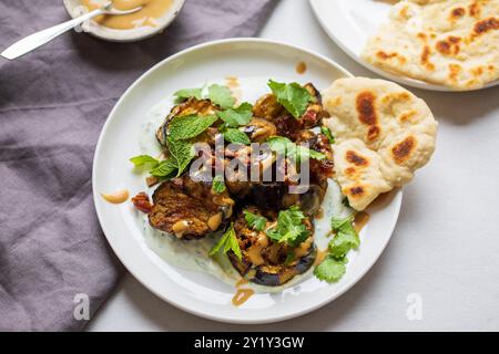 Aubergines rôties avec dattes, tahini et yaourt Banque D'Images