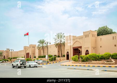 Murs fortifiés et porte du marché du souk arabe avec drapeau omanais agitant sur le toit, Nizwa, sultanat Oman Banque D'Images