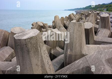 l'homme a fait une défense de mur de mer en béton défendant le rivage de la puissance de la mer. Banque D'Images