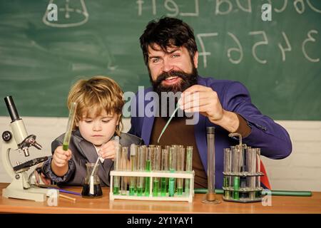 apprentissage de la chimie en laboratoire scolaire. Retour à l'école. Recherche scientifique et expériences homme enseignant avec petit garçon. Laboratoire de sciences biologiques. Père Banque D'Images