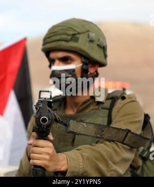 Tubas, Palestine. 24 novembre 2020. Les troupes israéliennes affrontent des manifestants palestiniens par le poste de contrôle de Tayasir dans le nord de la vallée du Jourdain, près de la ville de Tubas en Cisjordanie. Les Palestiniens protestent contre les 30 colonies israéliennes dans la vallée du Jourdain et la construction continue d'avant-postes israéliens illégaux dans la région aux dépens des terres palestiniennes. Ils s’opposaient également au plan israélien d’annexion de la vallée du Jourdain. La vallée du Jourdain comprend environ un tiers de la Cisjordanie, occupée par Israël depuis la guerre israélo-arabe de 1967 malgré les condamnations de l'U Banque D'Images