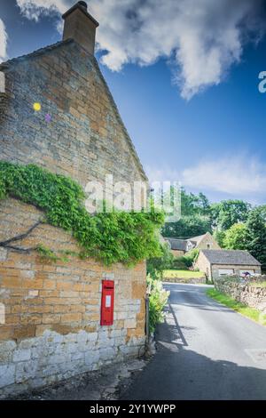 Boîte aux lettres rouge sur le mur de la maison du village Banque D'Images