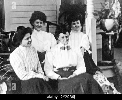 Quatre femmes assises sur un porche profitant de l'après-midi, vers 1910. Banque D'Images