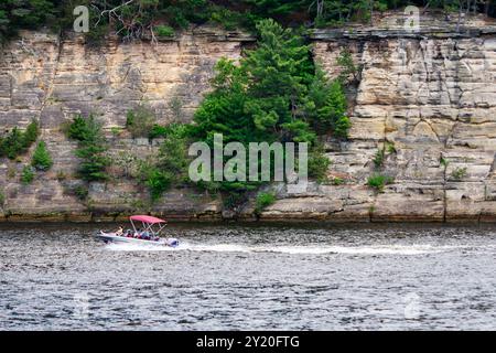 Un bateau navigue sur la rivière Wisconsin dans les Wisconsin Dells le long des falaises de grès cambriennes. Banque D'Images