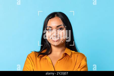 Femme souriante avec superposition de reconnaissance faciale sur un fond bleu Banque D'Images