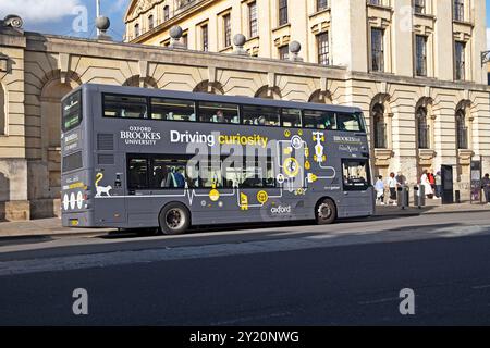 Vue d'une publicité promotionnelle sur le côté d'un autobus gris Oxford Brookes University à un arrêt de bus sur Aldates Oxford City Centre Oxfordshire 2024 KATHY DEWITT Banque D'Images