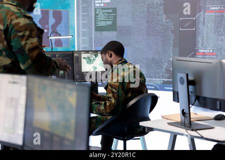 Les spécialistes militaires travaillent dans un centre de poste de commandement de haute technologie, en se concentrant sur la cybersécurité, la surveillance et la protection des données afin d’assurer la sécurité et l’intégrité des informations nationales. Banque D'Images