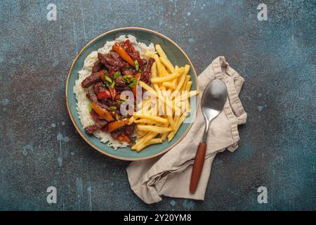 Lomo saltado, plat traditionnel péruvien, avec frites servies dans une assiette avec du riz Banque D'Images