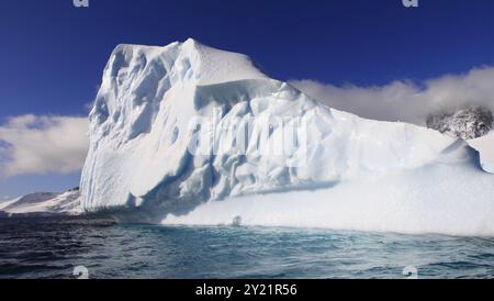 Magnifique iceberg en Antarctique dans les eaux Azur par une journée ensoleillée Banque D'Images