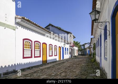 Rue pavée typique avec des bâtiments coloniaux sur une journée ensoleillée avec des ombres dans la ville historique de Paraty, Brésil, Amérique du Sud Banque D'Images