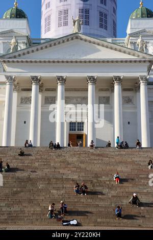 Personnes assises sur les marches de la cathédrale d'Helsinki, Helsingin tuomiokirkko, sur la place du Sénat, Senaatintori dans le centre d'Helsinki, Finlande août 2024 Banque D'Images