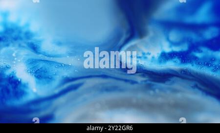 Éclaboussures de peinture. Déversement de liquide. Fond d'art abstrait du flux d'écoulement d'onde d'écoulement d'écoulement de flux de grain bleu défocalisé de texture de grain de couleur bleue. Banque D'Images