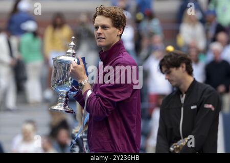 Le vainqueur Jannik Sinner, de l'Italie, célèbre la victoire pendant que Taylor Fritz, des États-Unis, regarde pendant la cérémonie du trophée de la 39 finale masculine du jour 14 de l'US Open, tournoi de tennis du Grand Chelem 2024, le 8 septembre 2024 au Centre national de tennis USTA Billie Jean King à Flushing Meadows, Queens, New York, États-Unis Banque D'Images