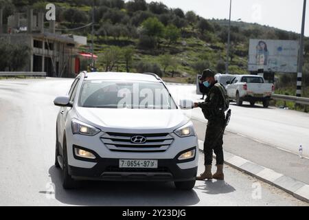 Tulkarem, Cisjordanie, Palestine. 09 mars 2021. Les membres des Forces de sécurité nationales palestiniennes vérifient les véhicules circulant dans la ville de Tulkarem, alors qu’un nouveau confinement est imposé en Cisjordanie pour contenir une nouvelle recrudescence de cas de COVID-19. Malgré un couvre-feu nocturne en place depuis une semaine, il y a eu une forte augmentation des cas de coronavirus parmi les Palestiniens en Cisjordanie. Les restrictions imposées par le confinement actuel comprennent la fermeture d'écoles, d'universités et d'entreprises non essentielles Banque D'Images