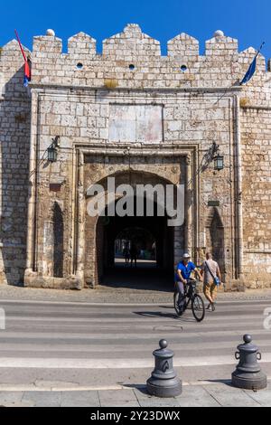 Un cycliste et un piéton à la porte Stambol - l'entrée principale de la forteresse de Nis en Serbie sur une belle journée d'été ensoleillée avec un ciel bleu. Banque D'Images