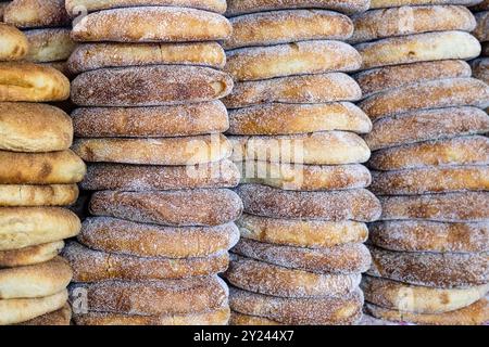 Pile de pain marocain frais à l'étal du marché de rue. Pain traditionnel fraîchement cuit appelé khubz, batbout, Mkhamer ou harcha au Maroc Banque D'Images