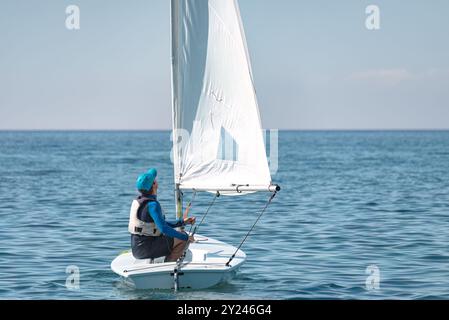 Bateau à voile de canot à voile de direction de sportif sur la mer calme Banque D'Images