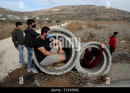 Naplouse, Cisjordanie, territoires palestiniens. 25 novembre 2021. Des affrontements ont éclaté entre l’armée israélienne et des jeunes Palestiniens dans la ville d’Al-Lubban al-Sharqiya, près de Naplouse, pour protester contre les attaques de colons contre les écoles palestiniennes de la région. Selon des sources locales, des colons et les forces israéliennes ont agressé jeudi matin des étudiants palestiniens qui se rendaient à l'école dans le village d'Al-Lubban Ash-Sharqiya. Elle fait suite à plusieurs attaques perpétrées ces derniers jours par des colons israéliens protégés par l'armée à l'école secondaire as-Sawiya et à l'école secondaire al-Lubban dans le sud de Naplouse, dans le cadre de l'augmentation de l'ACT Banque D'Images