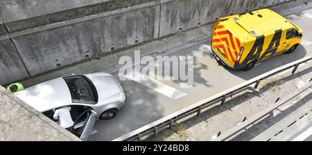 Voiture en panne déplacée de sous le pont de la route veste jaune AA mécanicien termine le travail conducteur entre dans le véhicule M25 autoroute épaule dure Essex Angleterre Royaume-Uni Banque D'Images