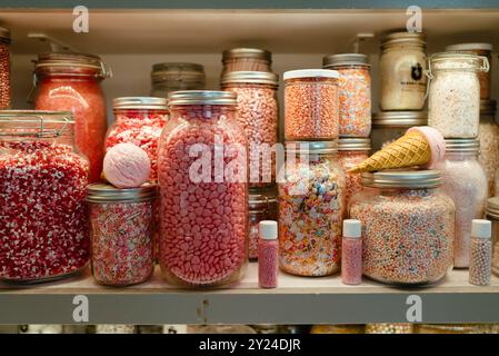 Bocaux remplis de divers bonbons roses et saupoudrés Banque D'Images