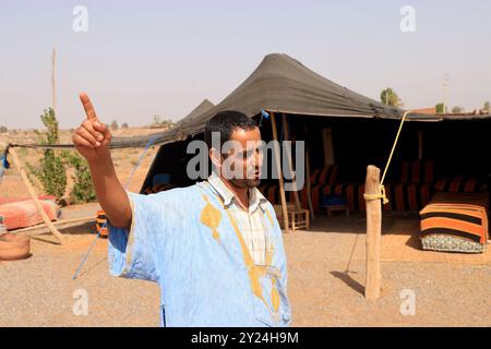 Camp nomade avec dromadaires et chauffeur de chameaux dans la campagne désertique près du moyen Atlas au Maroc. Maroc, Afrique du Nord. Crédit : photo par Hug Banque D'Images