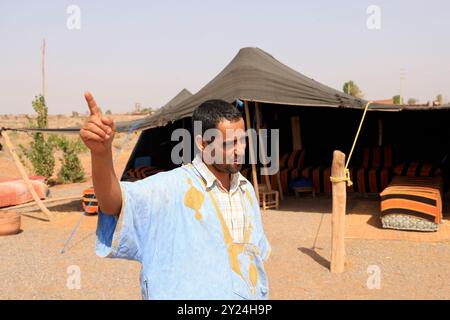 Camp nomade avec dromadaires et chauffeur de chameaux dans la campagne désertique près du moyen Atlas au Maroc. Maroc, Afrique du Nord. Crédit : photo par Hug Banque D'Images