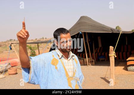 Camp nomade avec dromadaires et chauffeur de chameaux dans la campagne désertique près du moyen Atlas au Maroc. Maroc, Afrique du Nord. Crédit : photo par Hug Banque D'Images