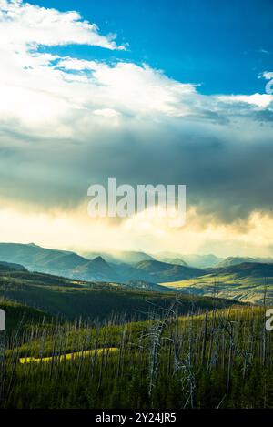 Montagnes couvertes de nuages à Yellowstone sous un ciel lumineux. Banque D'Images