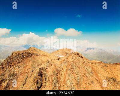 Vue aérienne chaîne de montagnes du caucase avec vallées colorées sur la zone alpine. Pic de montagne Kazbek en arrière-plan Banque D'Images