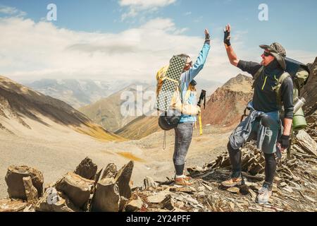 Deux randonneurs adultes caucasiens ensemble se tiennent dans les bras attentionnés sur le sommet de la montagne profiter du panorama. Homme et femme debout et serrés au sommet de la montagne Banque D'Images