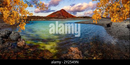 Montagne rouge et flaque verte près de la côte de la mer dans l'île des Canaries, Lanzarote. Plages d'Espagne. Banque D'Images