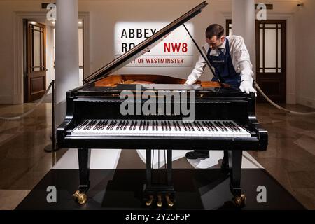 Londres, Royaume-Uni. 9 septembre 2024. Un technicien présente 'A Steinway Model A Grand Piano logé et utilisé dans Studio 3, 1973-2016' par Abbey Road Studios (est. £150 000 - 200,000) lors d'un aperçu de la première vente aux enchères en ligne de Sotheby's Popular culture. Des lots des mondes Rock, Pop et Britpop, et des films sont proposés accompagnés d’une exposition publique aux galeries Sotheby’s New Bond Street à partir du 9 septembre. Les offres sont clôturées le 12 septembre. Credit : Stephen Chung / Alamy Live News Banque D'Images