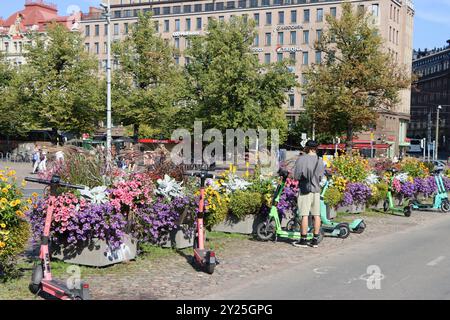 Scooters garés près des pots de jardin d'été de la ville sur la place Rautatientori dans le centre d'Helsinki, Finlande, août 2024 Banque D'Images