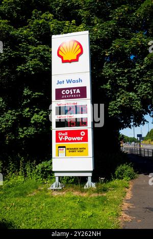 Newcastle UK : 8 juillet 2024 : Prix du carburant affichés dans une station-service Shell avec un service de lavage à jet dans un cadre extérieur ensoleillé près de Scotswood Road Banque D'Images